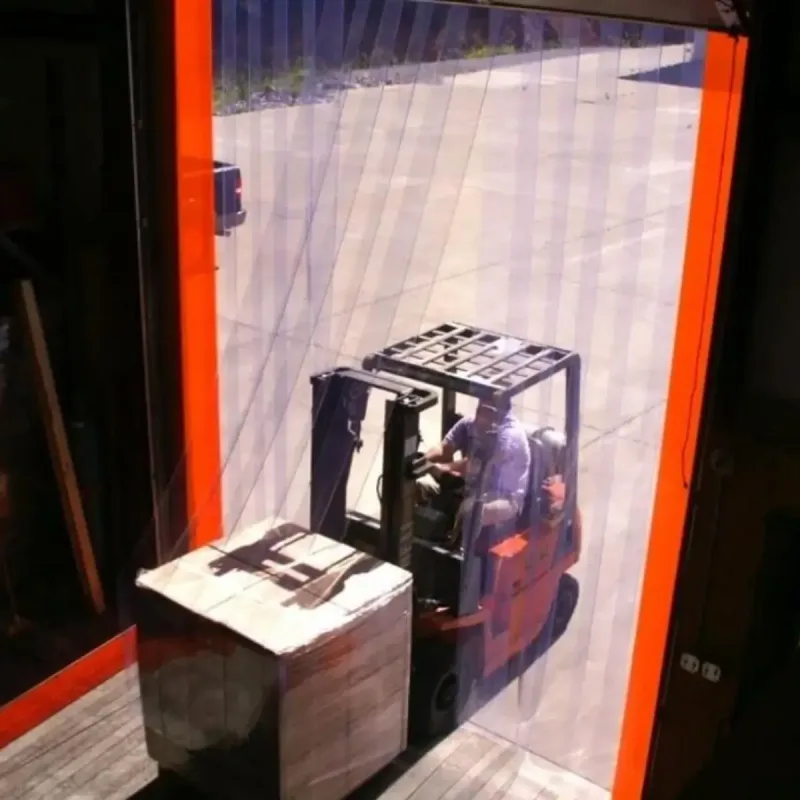 Forklift driving through a warehouse doorway with plastic PCV strip curtains