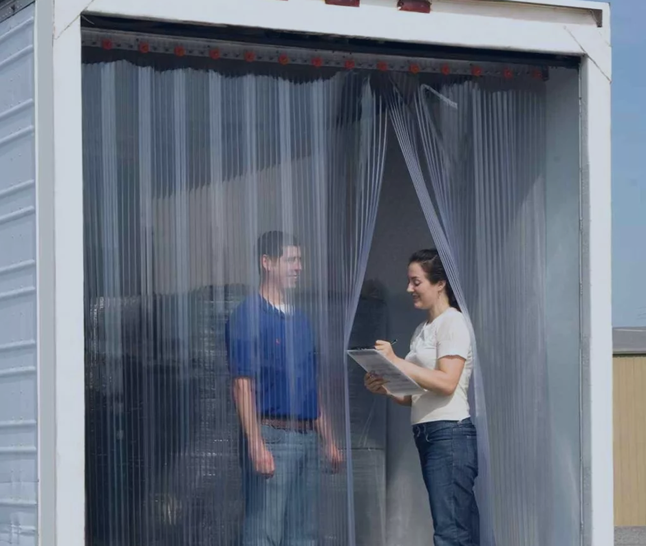 two people standing in a truck behind PVC strip curtains