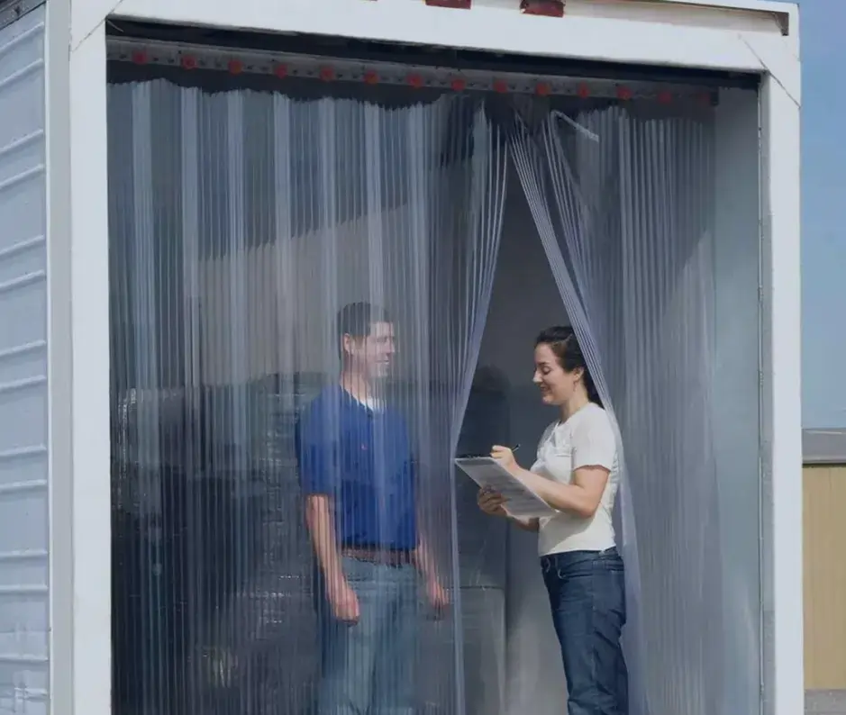 two people standing in a truck behind PVC strip curtains showing the best industries that use PVC strip curtains