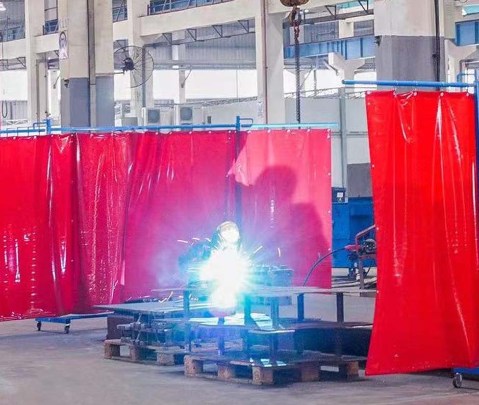 man welding with PVC welding curtains in a row with partitions