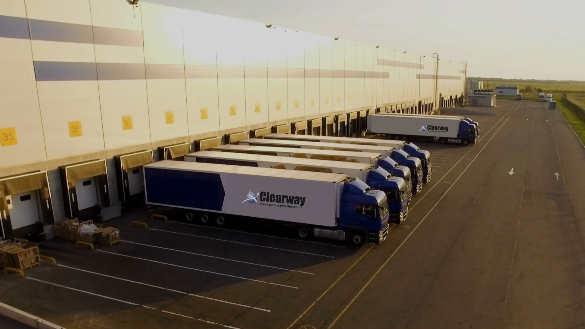 Clearway lorries outside a factory with branding on the trucks
