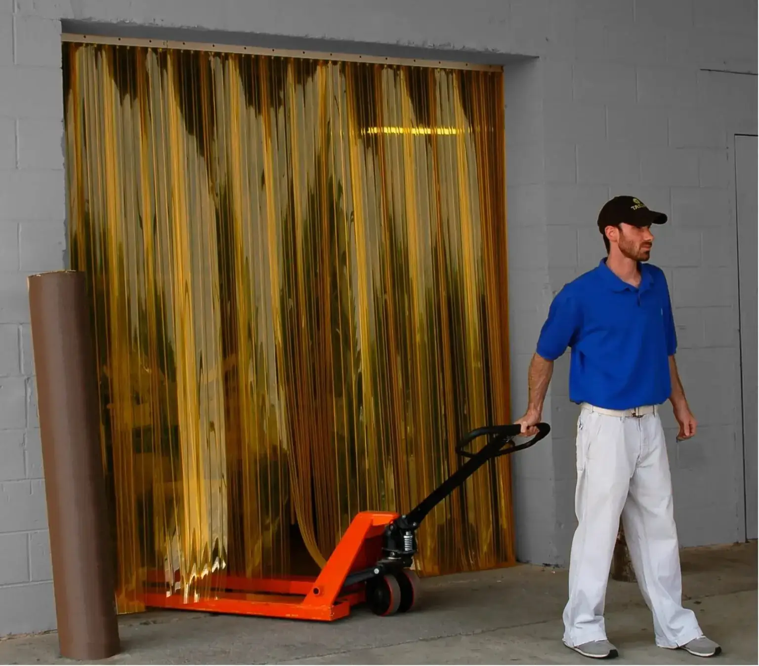 Yellow PVC strip curtains in a doorway with a man with trolley going through