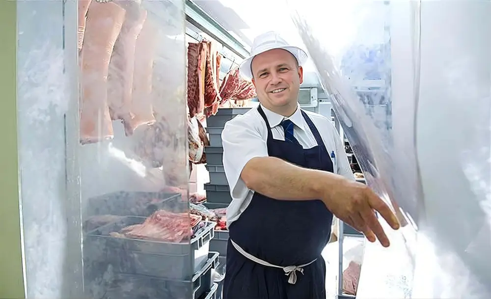 Plastic PVC strip curtains in a butchery with a man walking through the butcher curtains